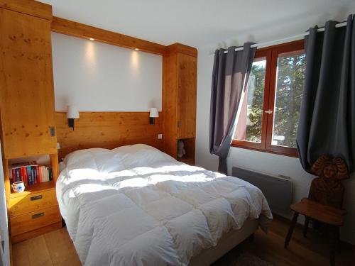 a bedroom with a large bed and a window at Chalet spacieux au soleil près des pistes, idéal pour 9 personnes - FR-1-445-219 in Montgenèvre