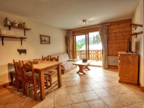 un salon avec une table et un canapé dans l'établissement Agréable appartement 2 chambres, pied des pistes à Morillon - FR-1-642-101, à Morillon