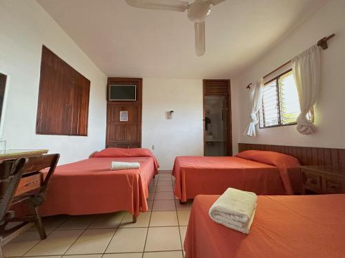 a hotel room with two beds and a window at Hotel San Juan in Puerto Escondido