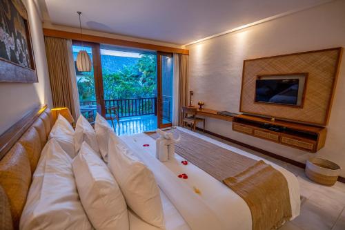 Una televisión o centro de entretenimiento en Purana Suite Ubud