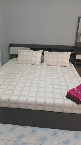 a bed with white sheets and pillows on it at Chez mamie in Pattaya South