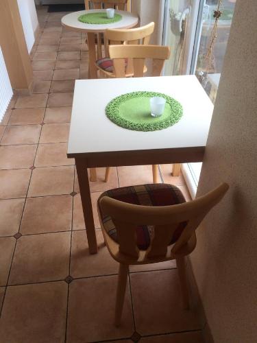 a table with a chair and a green plate on it at Pension Hönel-Hof Bad Schandau in Bad Schandau