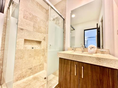 a bathroom with a shower and a sink at Perfect Condo at Arenis, Oceanview Pool and Gym in Playa del Carmen
