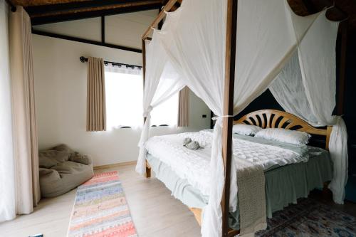un dormitorio con una cama con dosel en Uma Valley Homestay - Nature Oasis near Hay Yai, en Ban Wang Ching