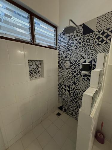 a bathroom with a shower with black and white tiles at Hotel San Juan in Puerto Escondido