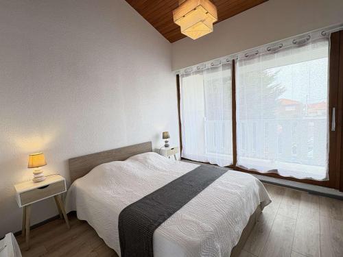 une chambre avec un lit et une grande fenêtre dans l'établissement La Garole 1 – Idéal pour 4 personnes près de l'Océan - FR-1-831-1, à Biscarrosse