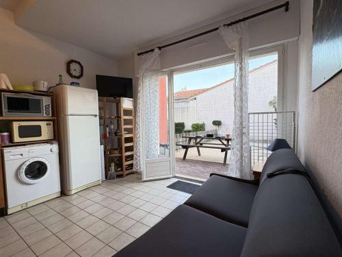 un salon avec un canapé et une cuisine avec une fenêtre dans l'établissement Appartement cosy avec terrasse pour 4 personnes à Biscarrosse Plage - FR-1-831-4, à Biscarrosse
