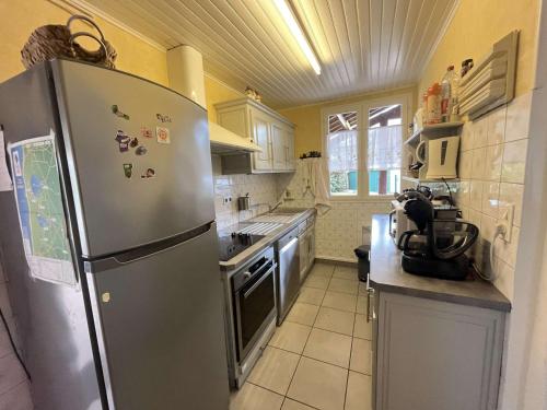 une cuisine avec un réfrigérateur en acier inoxydable dans l'établissement Villa rénovée près du lac, Biscarrosse - FR-1-831-2, à Biscarrosse