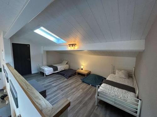 Cette chambre mansardée comprend deux lits et un canapé. dans l'établissement Villa d'exception avec piscine chauffée proche océan à Biscarrosse Plage - FR-1-831-8, à Biscarrosse