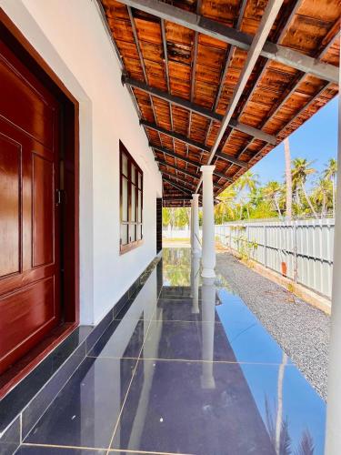 an external view of a house with a wooden ceiling at Riverrootsstays in Munroe Island