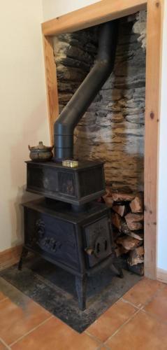 an old wood stove with a pile of logs at Gite le plan in Saint-Martin-de-Lansuscle