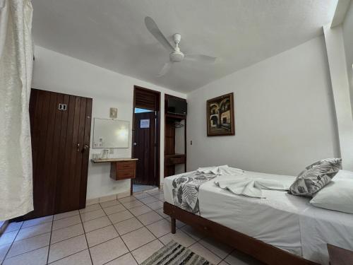 a bedroom with a bed and a bathroom at Hotel San Juan in Puerto Escondido
