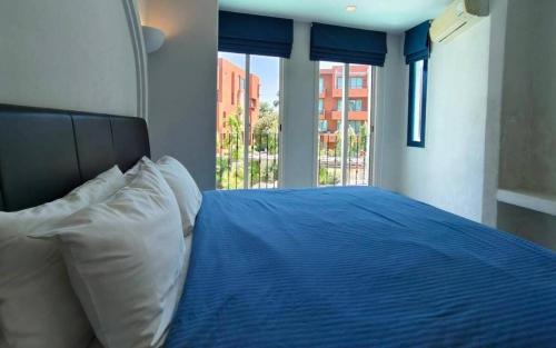 a bedroom with a blue bed with a window at Chelona Greece Beachfront! - 2 BR n FREE NETFLIX in Khao Tao