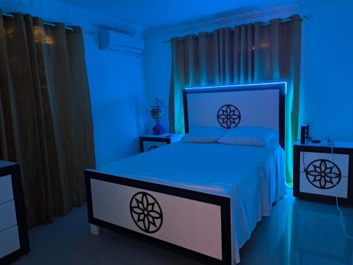 a bedroom with a bed with a blue light at Mariposa in Juan López