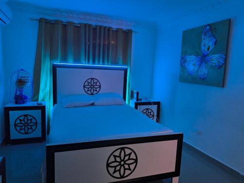 a bedroom with a bed with a blue light at Mariposa in Juan López