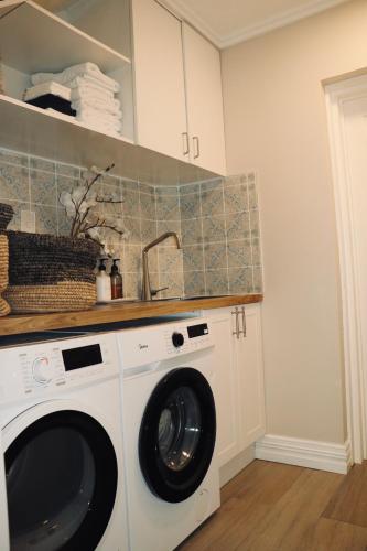 a white washer and dryer in a kitchen at Maison de Hobson Luxury guest suite in Auckland