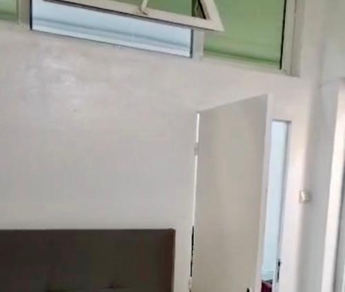 a white wall with a window and a air conditioner at Appartement Hypercentre Yaoundé in Yaoundé