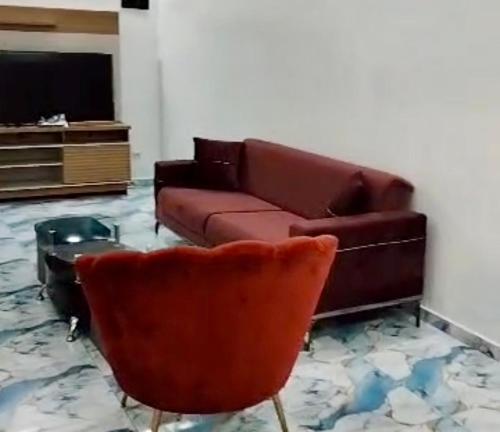 a living room with a couch and a chair at Appartement Hypercentre Yaoundé in Yaoundé