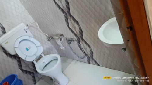 a small bathroom with a toilet and a sink at Joshi Holiday Home Stay in Lansdowne