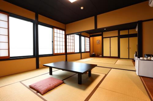 a large room with a table and some windows at 潮乃美 in Himi