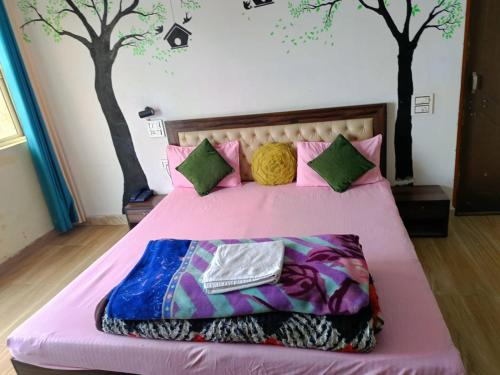 a bedroom with a bed with trees on the wall at Joshi Holiday Home Stay in Lansdowne