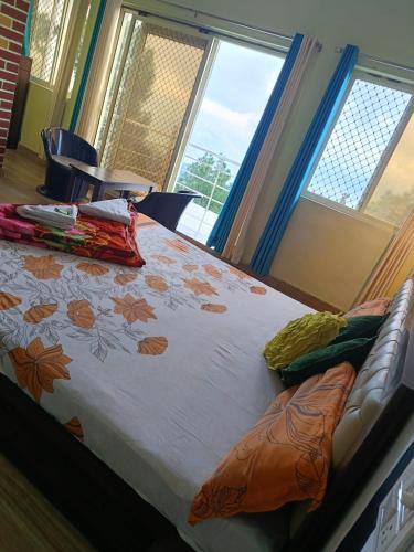 a bed in a room with two windows at Joshi Holiday Home Stay in Lansdowne