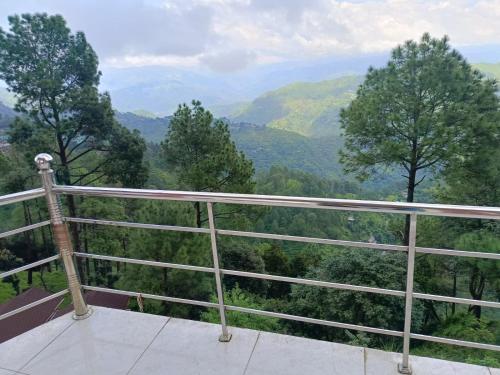 a balcony with a view of a mountain valley at Joshi Holiday Home Stay in Lansdowne