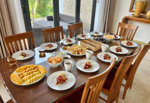 een houten tafel met borden met eten erop bij Blue Sky & Villas Beach Resort in Da Nang