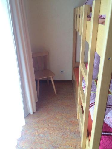 a bedroom with a bunk bed and a chair at Pension Hönel-Hof Bad Schandau in Bad Schandau
