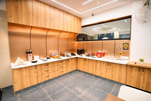 een keuken met houten kasten en een grote spiegel bij Sunrise Business Hotel, S R Nagar - Ameerpet in Hyderabad