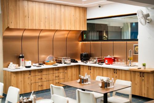 een restaurant met een tafel en stoelen en een keuken bij Sunrise Business Hotel, S R Nagar - Ameerpet in Hyderabad