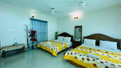 a bedroom with two beds and a mirror at Hotel Nice Look in Kuākāta
