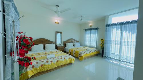 two beds in a large room with windows at Hotel Nice Look in Kuākāta
