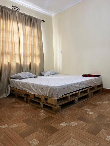 a large bed in a room with a window at 'La Maison' 2 bedroom house in Arusha in Arusha