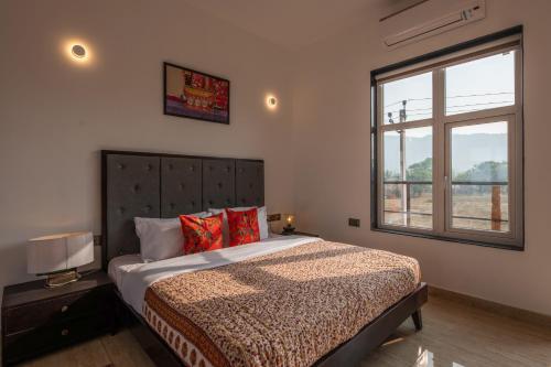 a bedroom with a large bed and a window at Aranyavas Nature Retreat, Jaipur in Jaipur