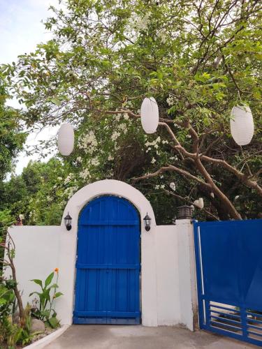 a blue door in a white wall with a tree at Don Ignacio's Place in Cabancalan