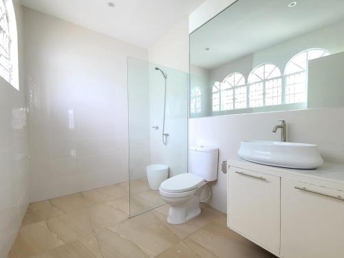 a white bathroom with a toilet and a sink at Don Ignacio's Place in Cabancalan