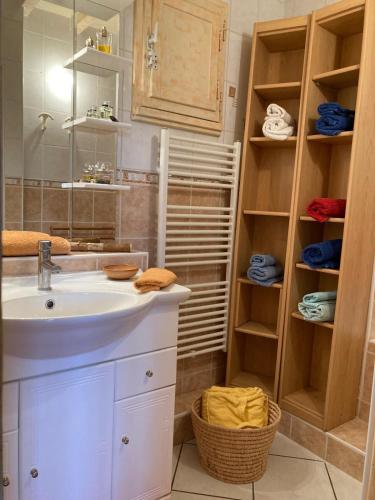 une salle de bain avec un lavabo et un miroir dans l'établissement Maison NICOLA, à Fréjus
