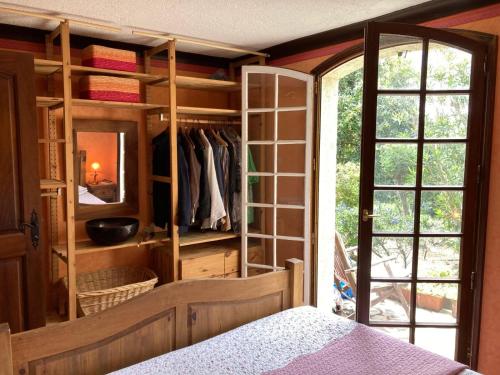- une chambre dotée d'un placard avec un lit et un miroir dans l'établissement Maison NICOLA, à Fréjus