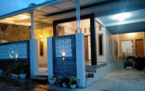 a house with a blue wall and some plants at Tafufu Villa Tumpak Sewu in Sumberbopong