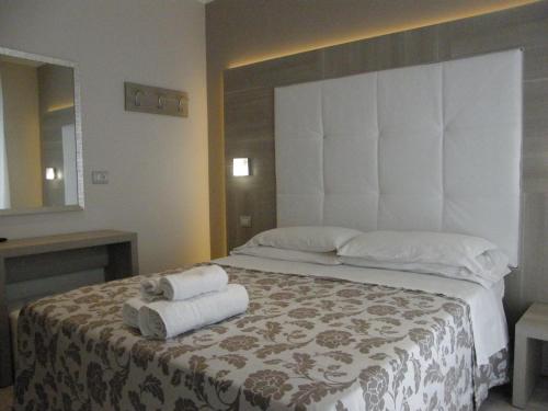 a bedroom with a large bed with towels on it at Hotel Stefan Room & Breakfast in Gatteo a Mare