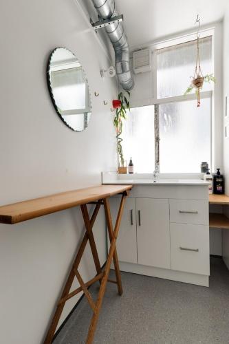 a kitchen with a table and a mirror on the wall at Cuba St Apartment & Parking in Wellington