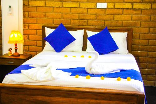 a swan sitting on a bed with blue pillows at Sigiriya Dream Inn in Sigiriya