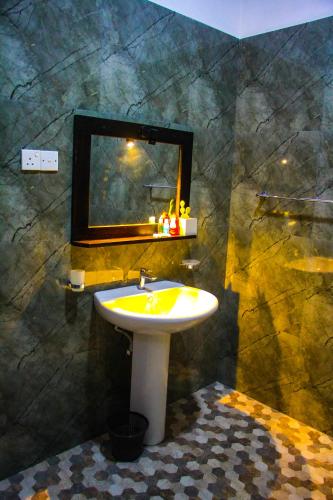 a bathroom with a sink and a mirror at Sigiriya Dream Inn in Sigiriya