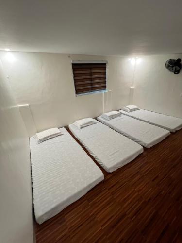 a room with four mattresses lined up against a wall at Antonia Transient House in Calingcuan