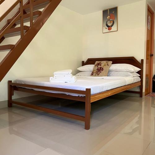 a bed with a wooden frame in a room at Antonia Transient House in Calingcuan