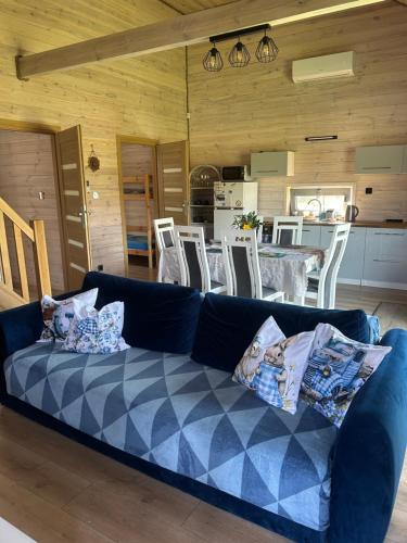 a blue couch in a living room with a table at Mazury Dom Oluś nad jeziorem Sasek Wielki z gorącą balia z funkcją jakuzzi in Szczytno