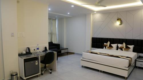a bedroom with a bed and a desk in a room at Hotel Mandi Heights - Bar, Fine Dining & Banquet Hall in Mandi