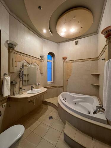 a bathroom with a tub and a toilet and a sink at MIMFRI PREMIUM guest house, hotel in Tashkent