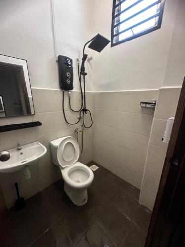 a bathroom with a white toilet and a sink at Tepi Villa Private Pool PD in Port Dickson